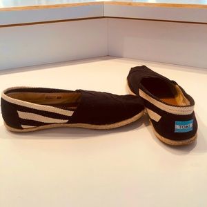 TOMS slip-ons. Black with off white striping on sides and tweed sole